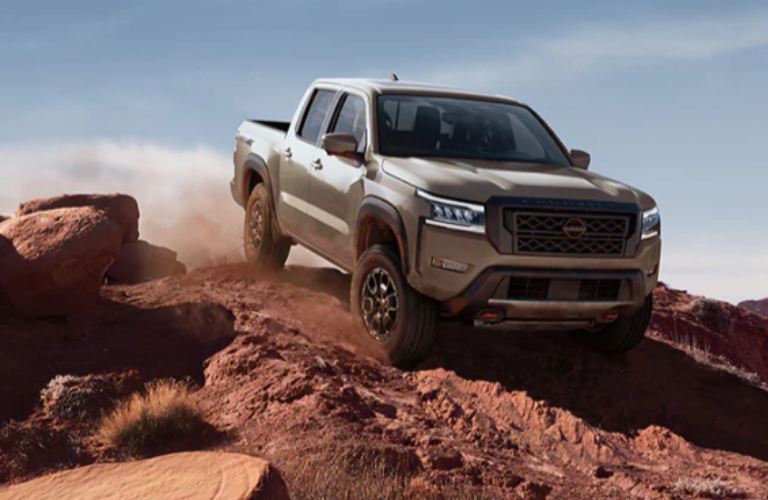 A man driving the 2024 Nissan Frontier on rough terrain